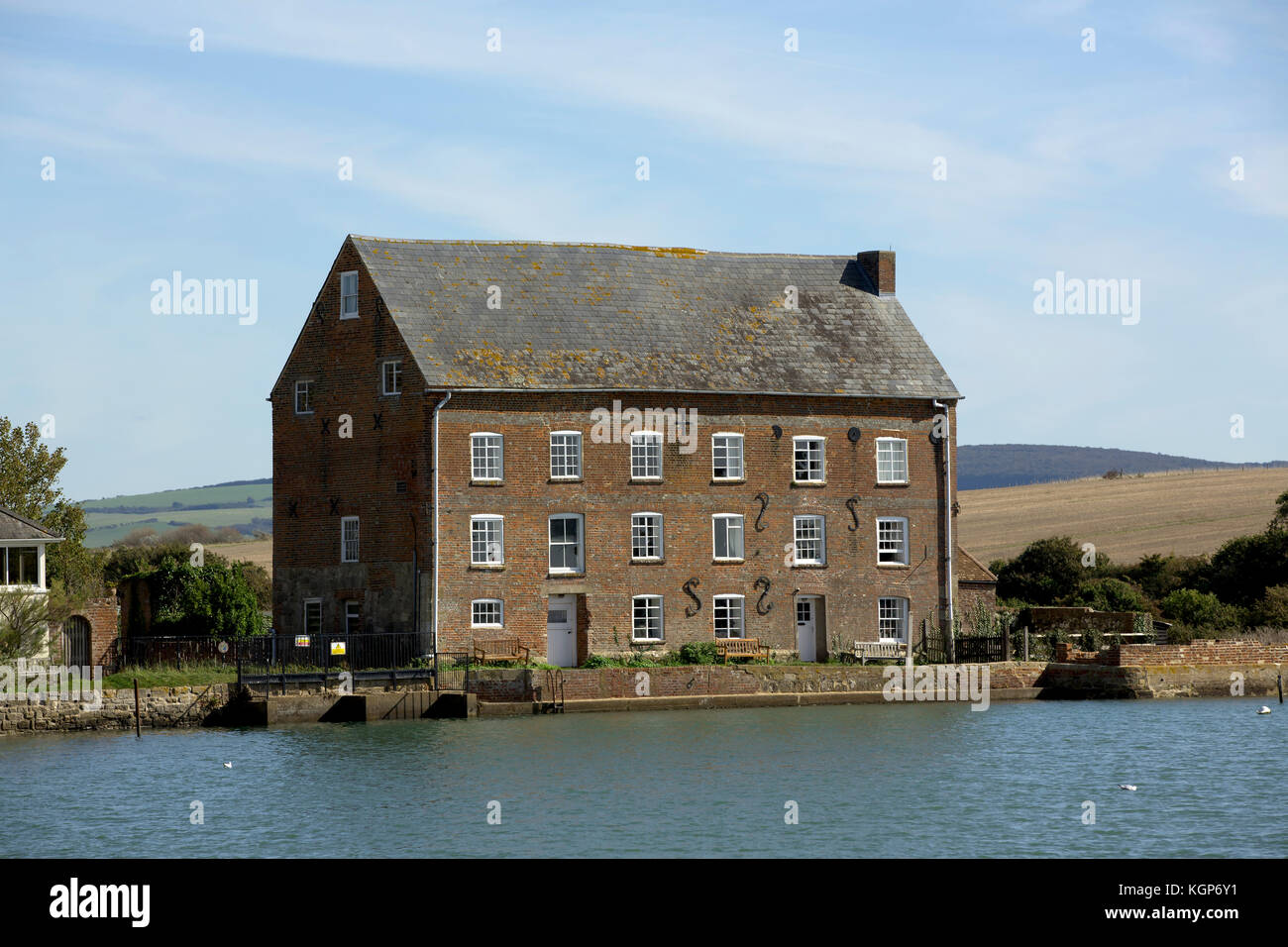 Il vecchio edificio del mulino convertito in case a Yarmouth sull'Isola di Wight. Situato sul fiume Yar in un ambiente idilliaco. Foto Stock