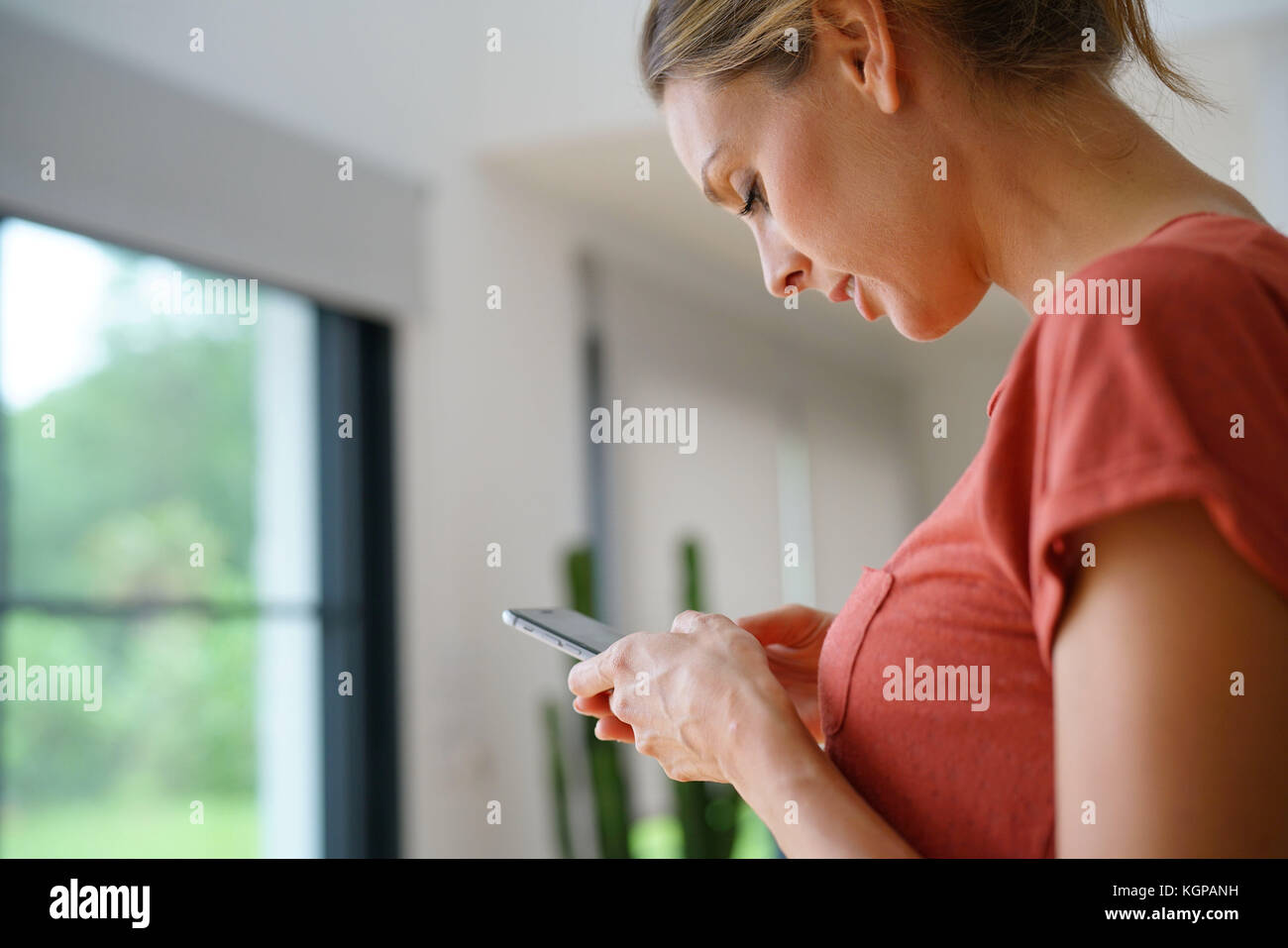 Donna di inviare un messaggio di testo con lo smartphone Foto Stock