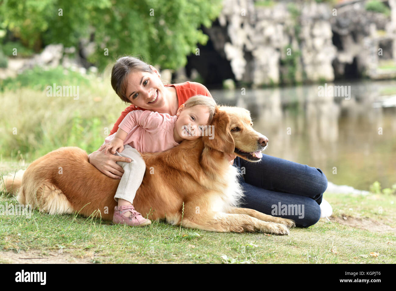 Donna e bambina gioca con il golden retriever cane Foto Stock