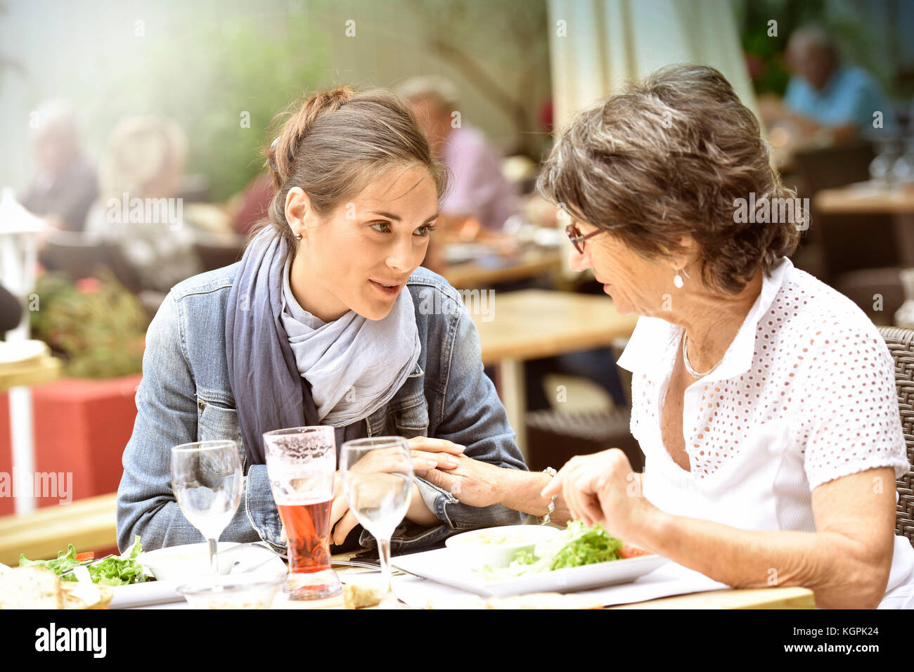 Senior donna con home caregiver avente un pranzo al ristorante Foto Stock