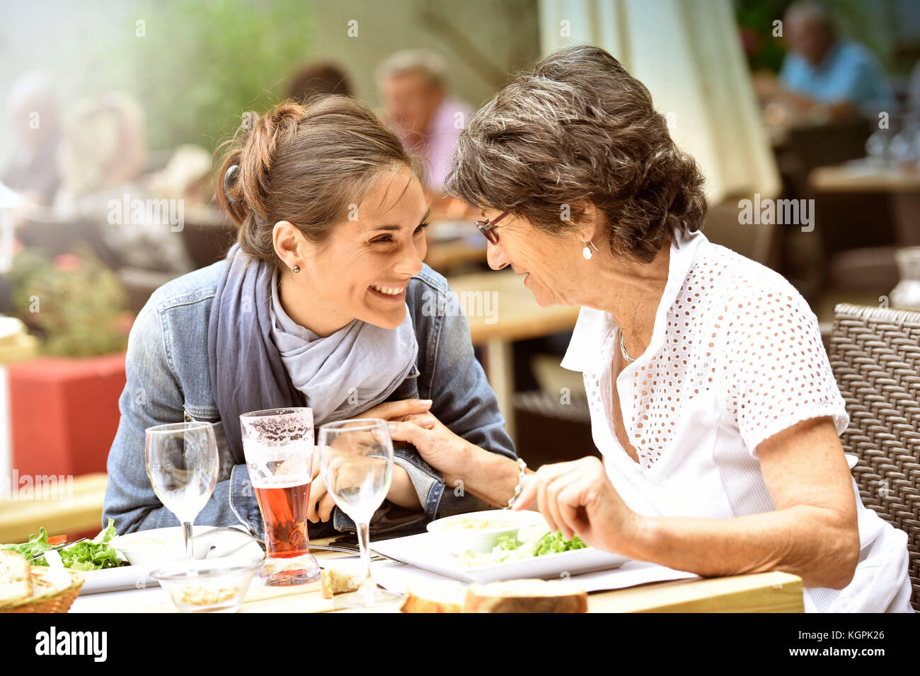 Senior donna con home caregiver avente un pranzo al ristorante Foto Stock