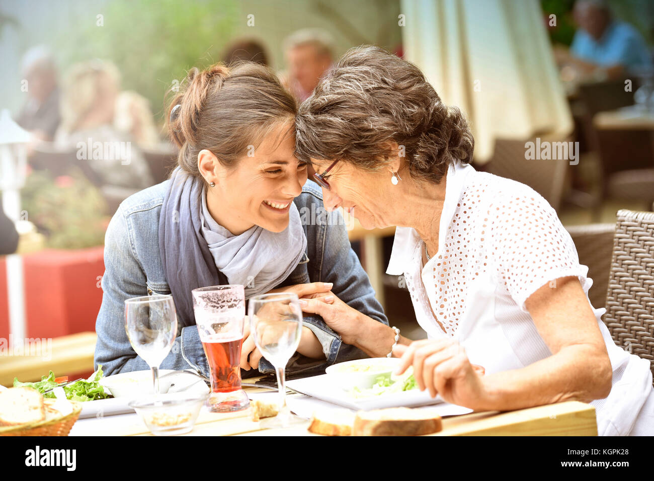 Senior donna con home caregiver avente un pranzo al ristorante Foto Stock