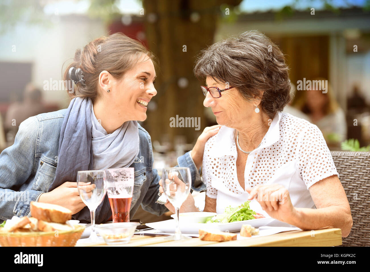 Senior donna con home caregiver avente un pranzo al ristorante Foto Stock