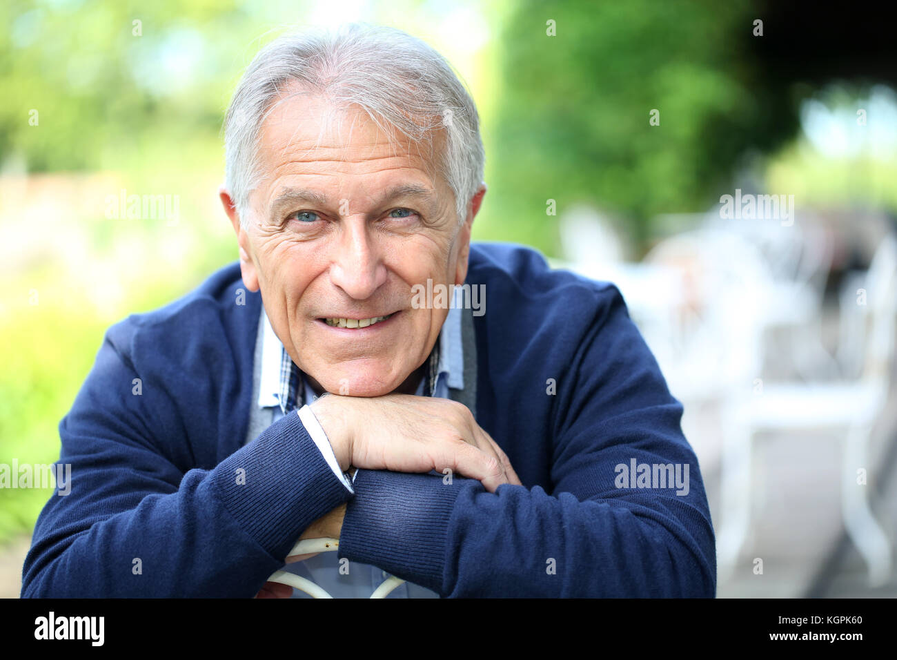 Ritratto di senior uomo seduto nel giardino di casa Foto Stock