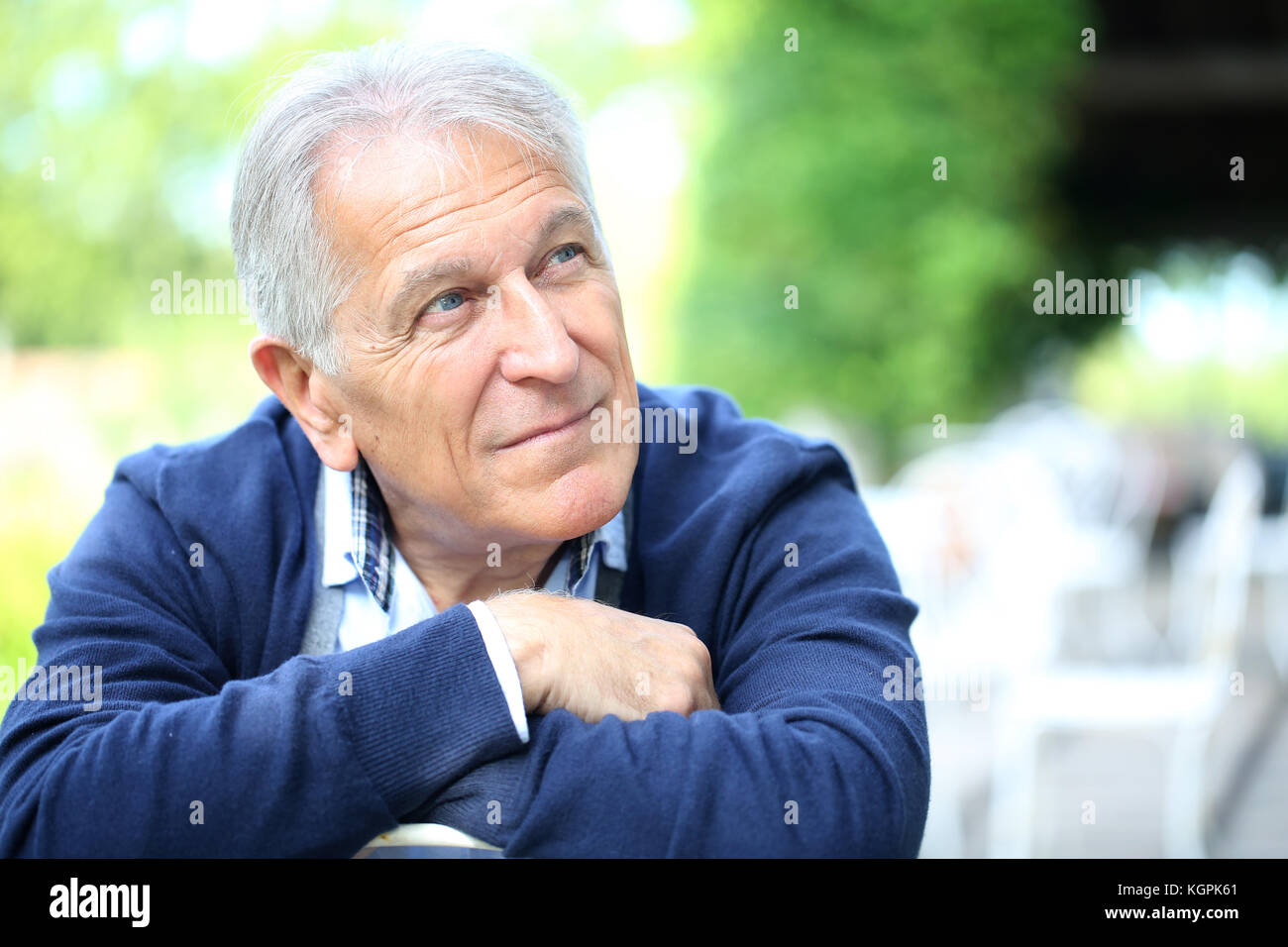 Ritratto di senior uomo seduto nel giardino di casa Foto Stock