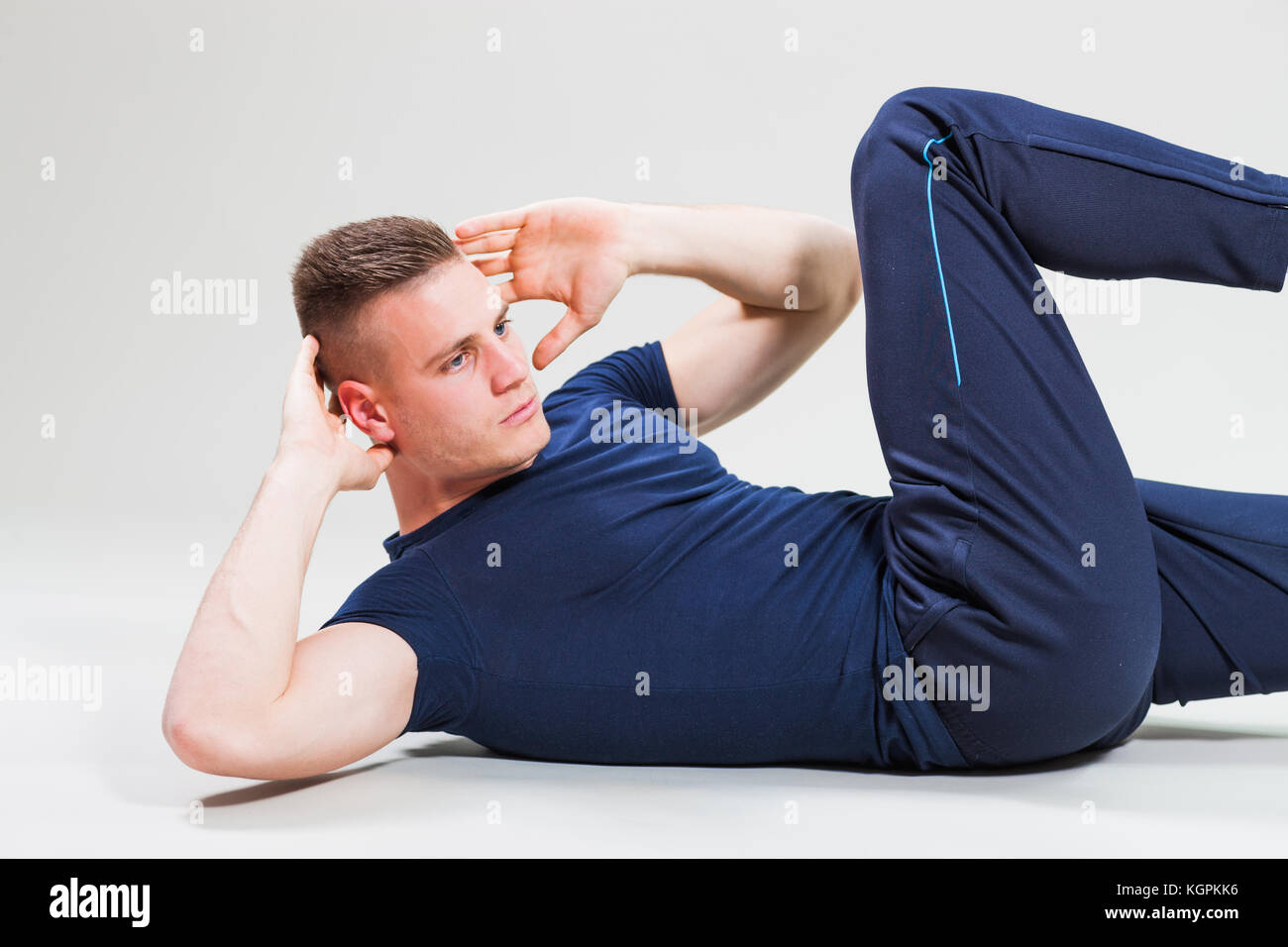 Studio shot immagine del giovane uomo che sta facendo scricchiola. Foto Stock