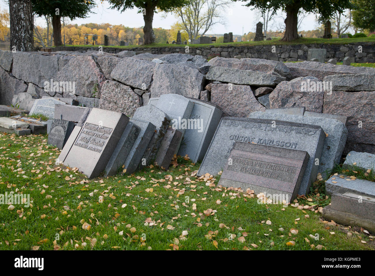 Le lapidi da completato tombe sono state fissato contro la parete di cimitero in attesa per il riutilizzo Foto Stock