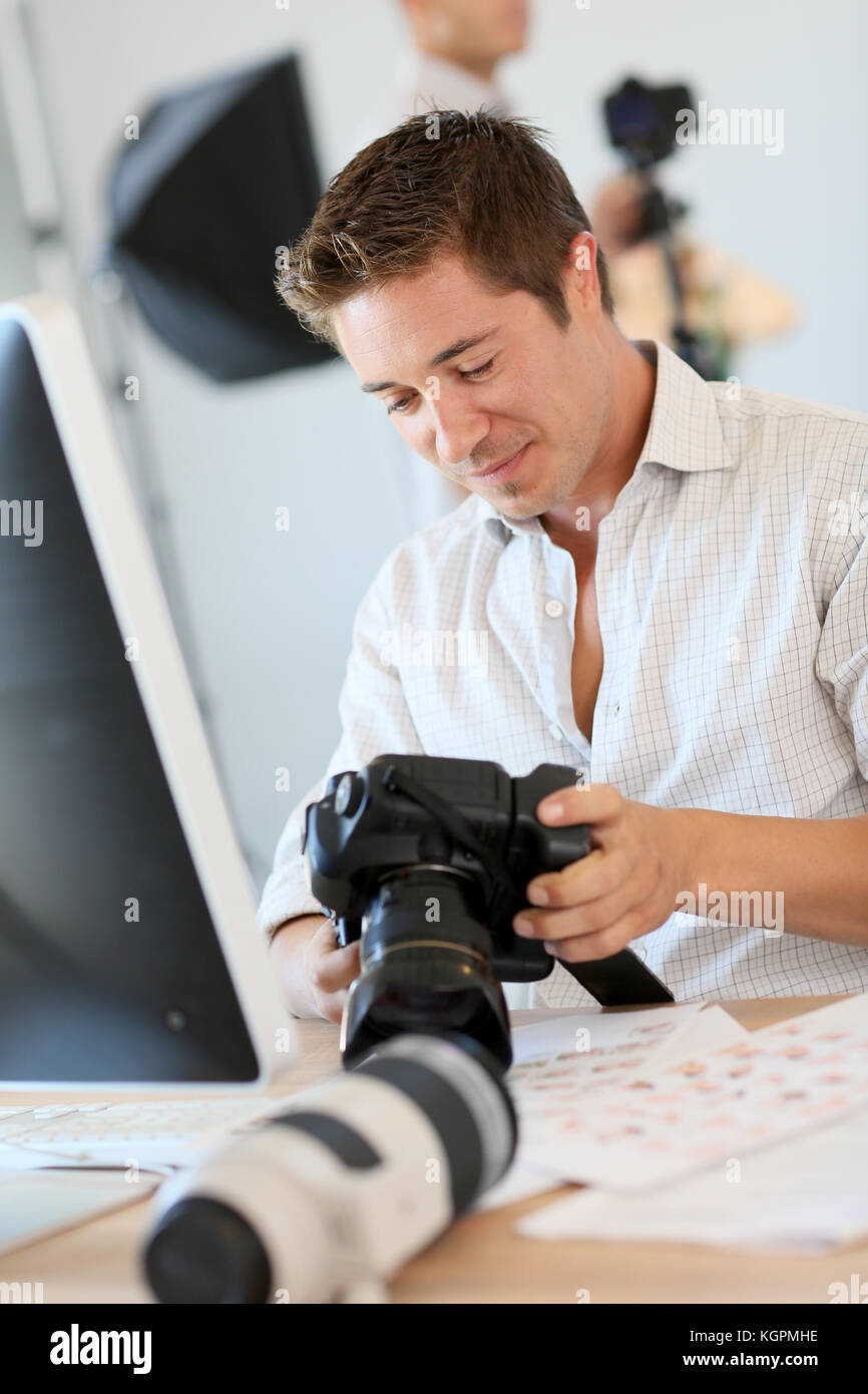 Fotografo guardando scatti sullo schermo del computer Foto Stock