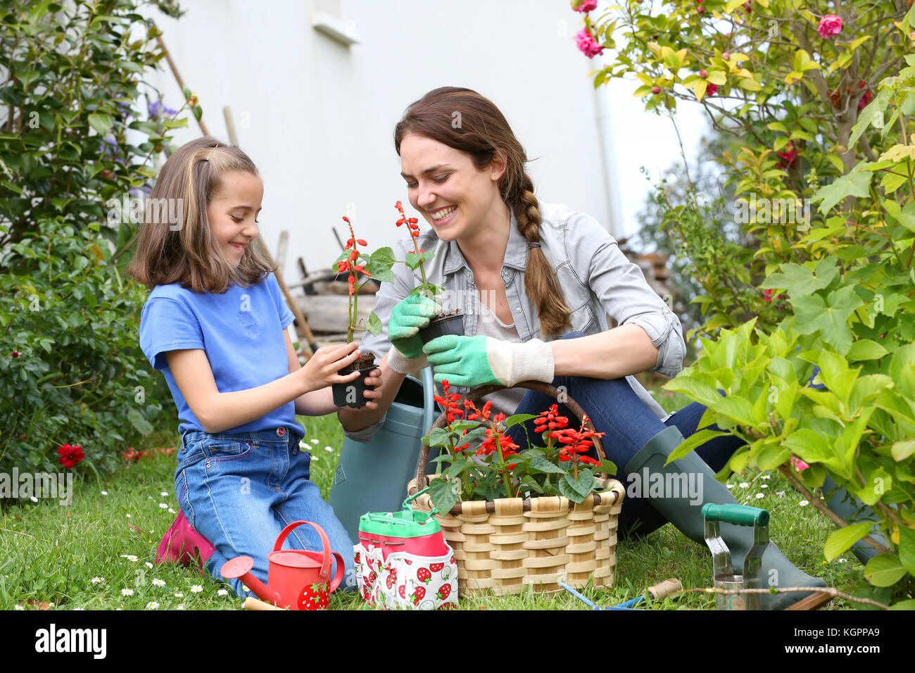 Bambina aiutando la madre a fare giardinaggio Foto Stock