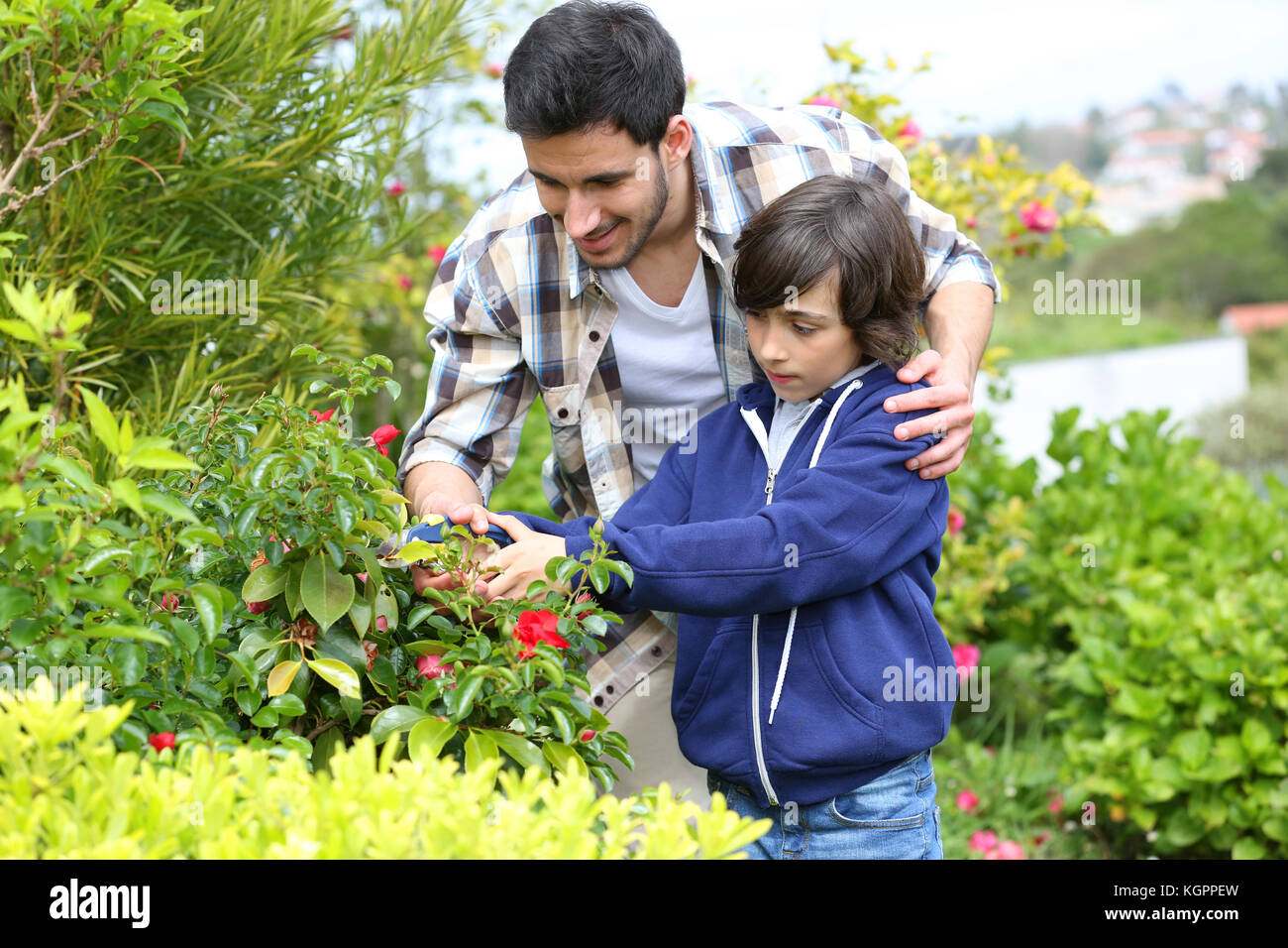 Il daddy insegnamento ragazzino di fare giardinaggio Foto Stock