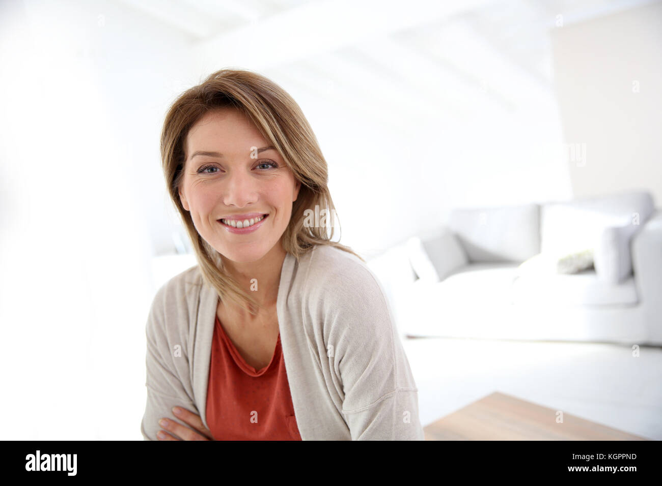 Donna di mezza età in piedi in casa moderna Foto Stock