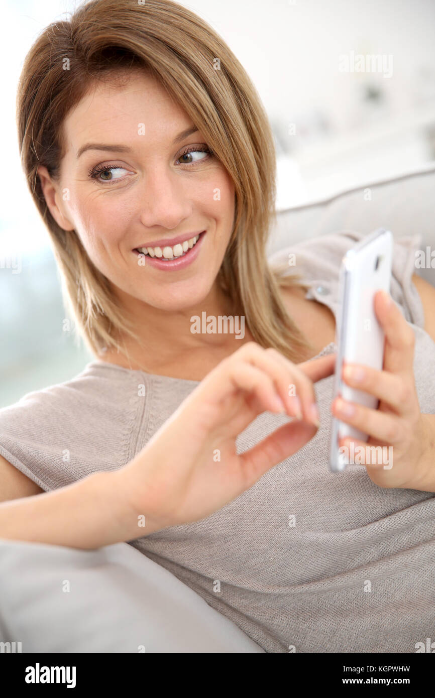Donna di mezza età inviando un messaggio con lo smartphone Foto Stock
