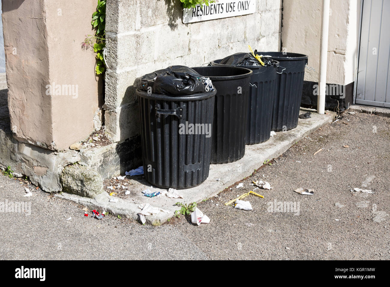 In plastica nera cassonetti con residenti utilizzare solo segno Foto Stock