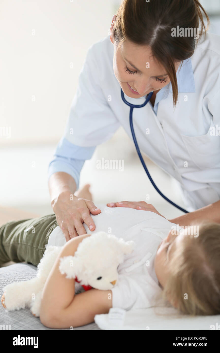 Pediatra esaminando bambino lo stomaco Foto Stock