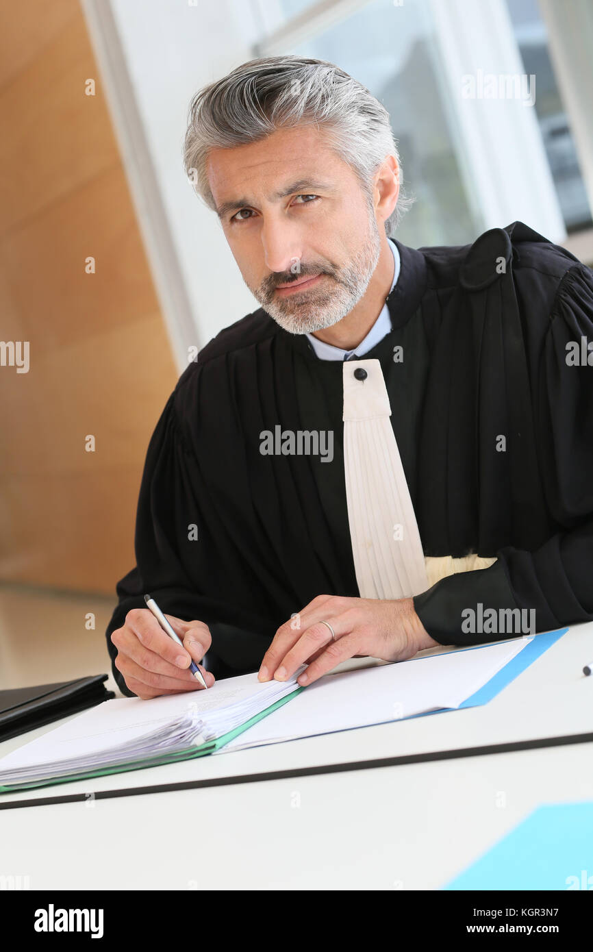 Avvocato maturo lavorando sulla relazione di giudizio Foto Stock