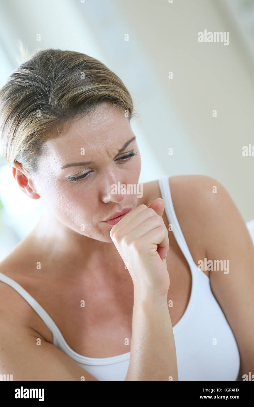 Donna di mezza età avente un freddo e la tosse Foto Stock