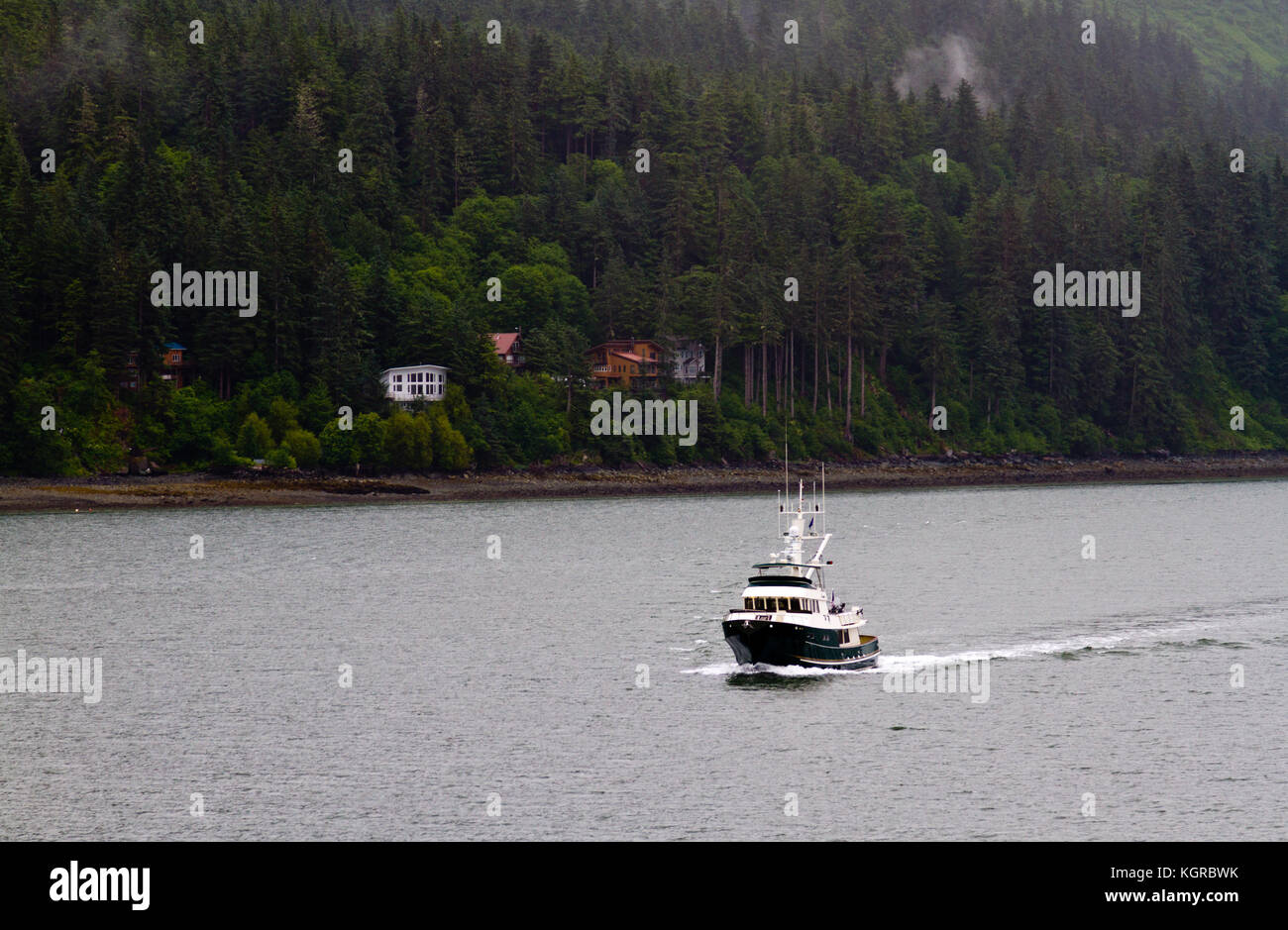 Una barca da pesca crociera lungo la costa in Alaska vicino a Ketchikan. Foto Stock