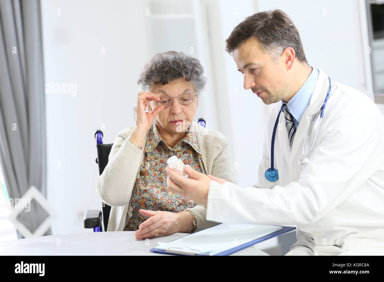 Medico con una donna anziana che mostra la prescrizione medica Foto Stock