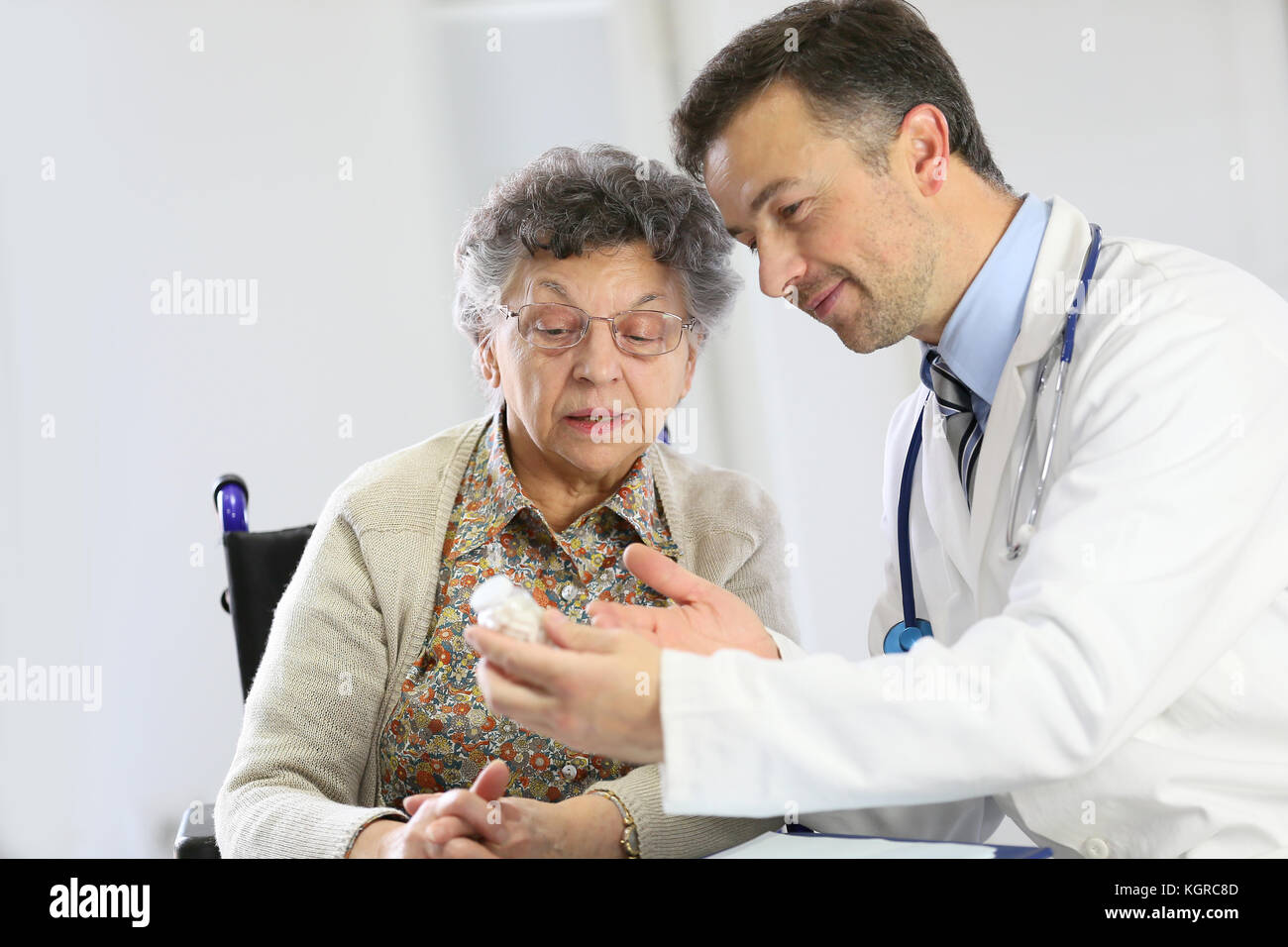 Medico con una donna anziana che mostra la prescrizione medica Foto Stock