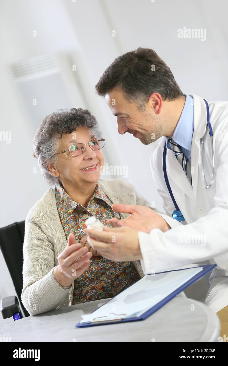 Medico con una donna anziana che mostra la prescrizione medica Foto Stock
