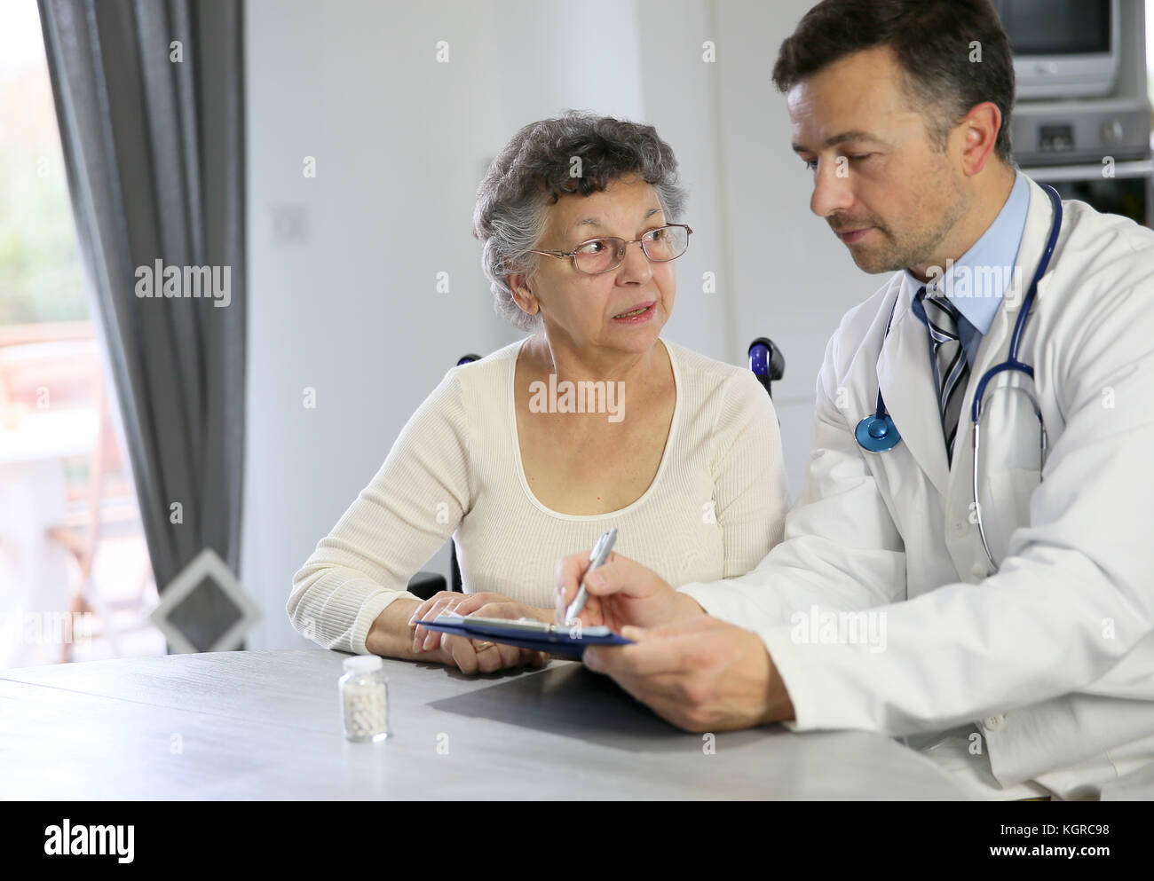 Medico iscritto prescrizione medica per la donna anziana Foto Stock