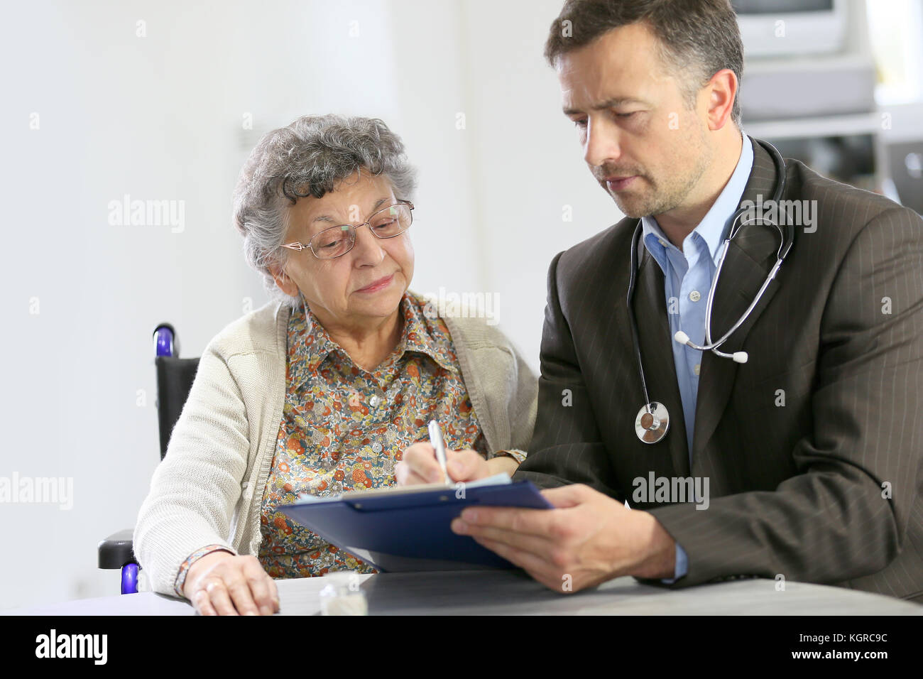 Visita medico paziente anziano a casa Foto Stock