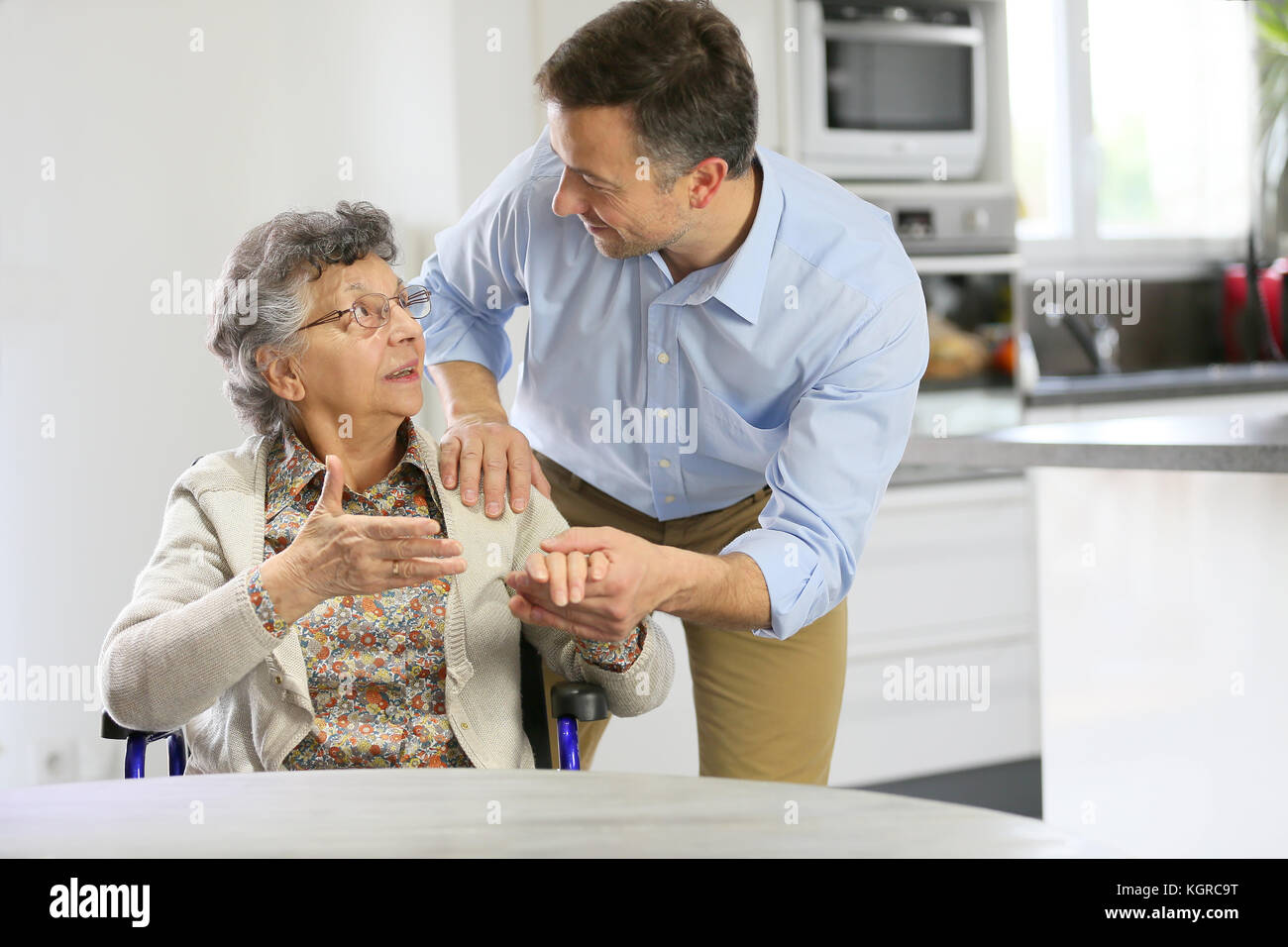 Portatore di casa che sostiene le donne anziane a casa Foto Stock