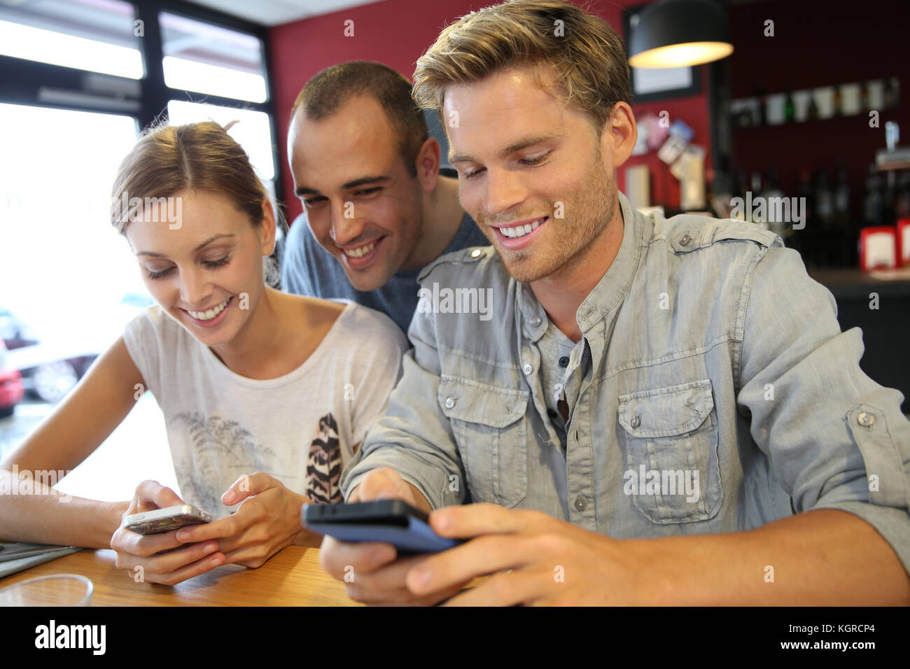 I giovani nel campus lounge collegato sullo smartphone Foto Stock