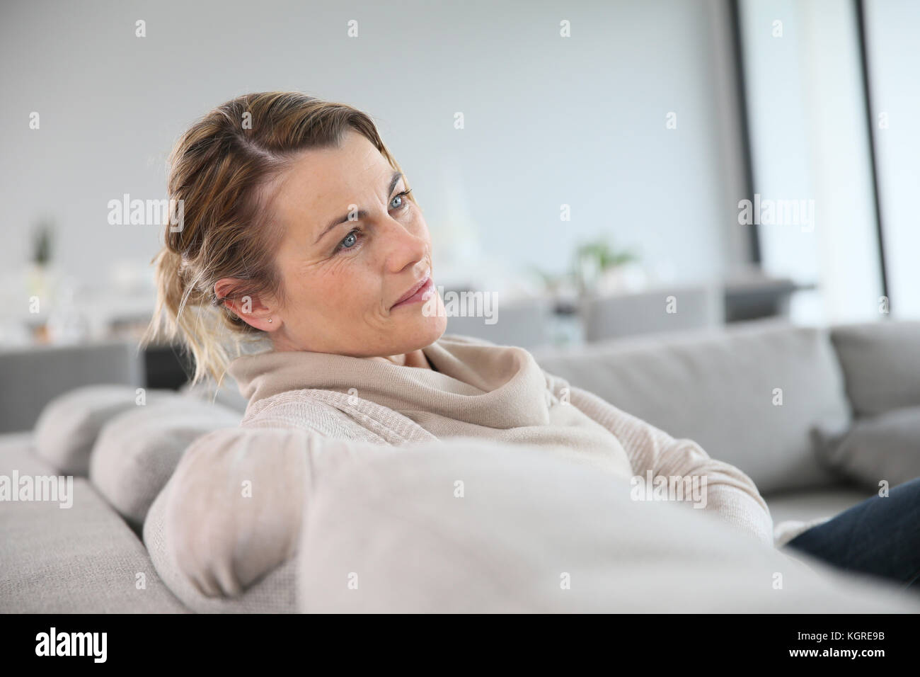 Tranquillo di mezza età donna seduta in divano Foto Stock