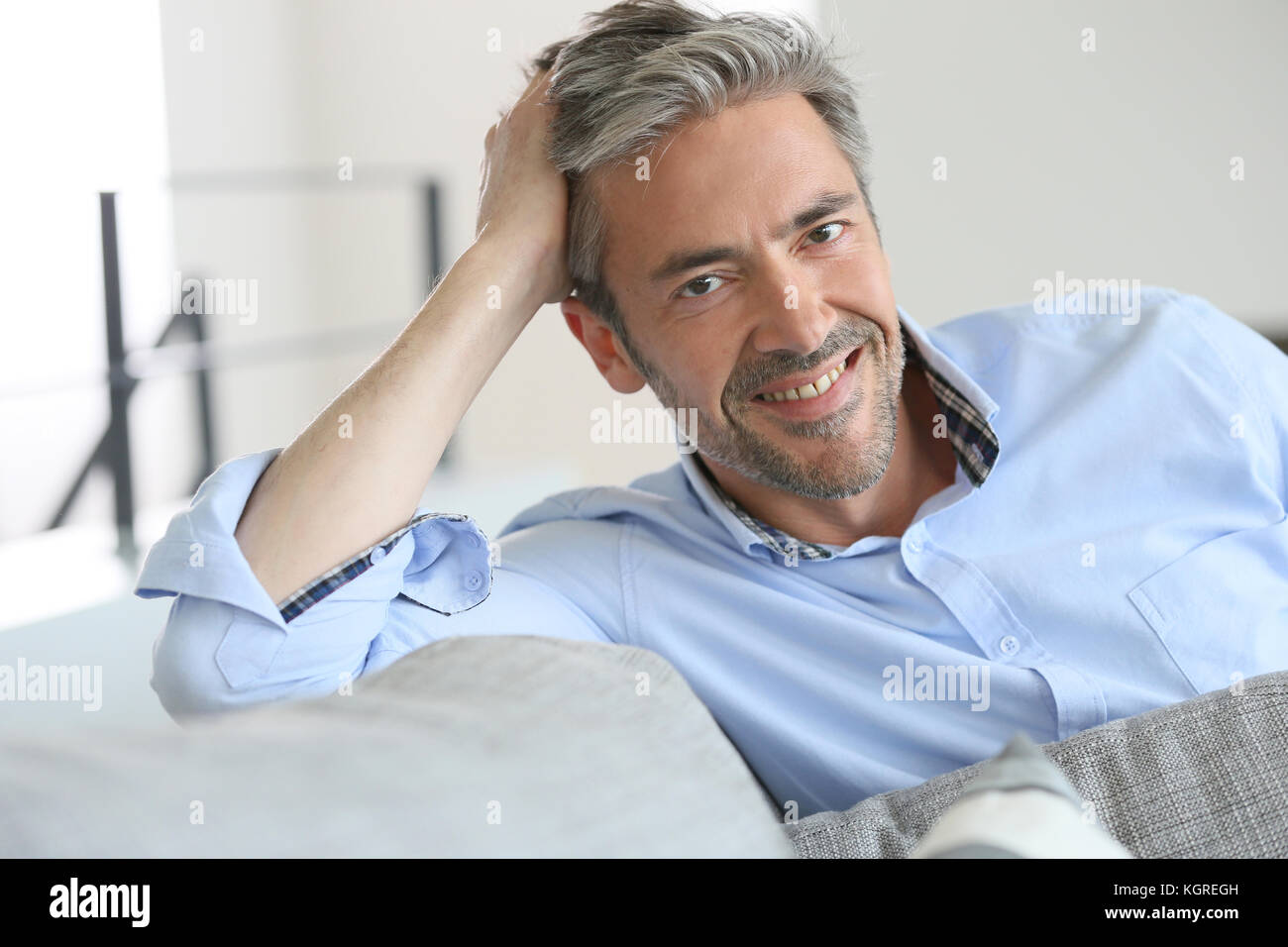 Sorridente bello 45-anno-vecchio uomo in un momento di relax a casa Foto Stock