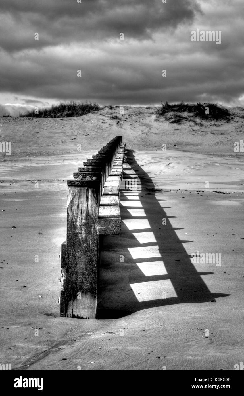 Un groyne soleggiato in tutta la spiaggia a Dawlish Warren, elaborata come una immagine HDR. Foto Stock