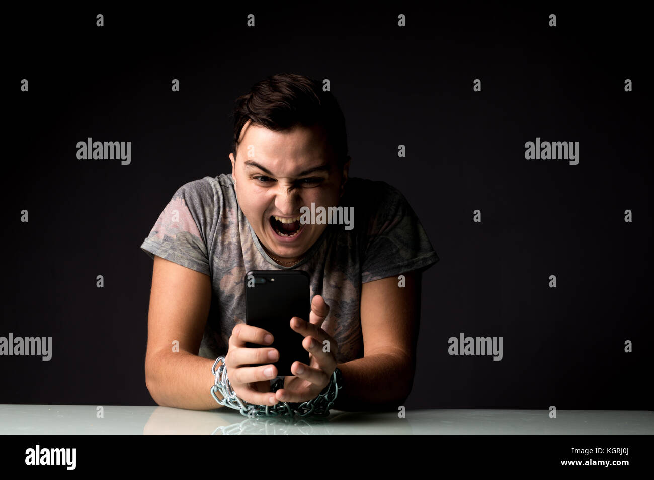 L uomo che soffre di dipendenza dal telefono della dipendenza in dark room Foto Stock