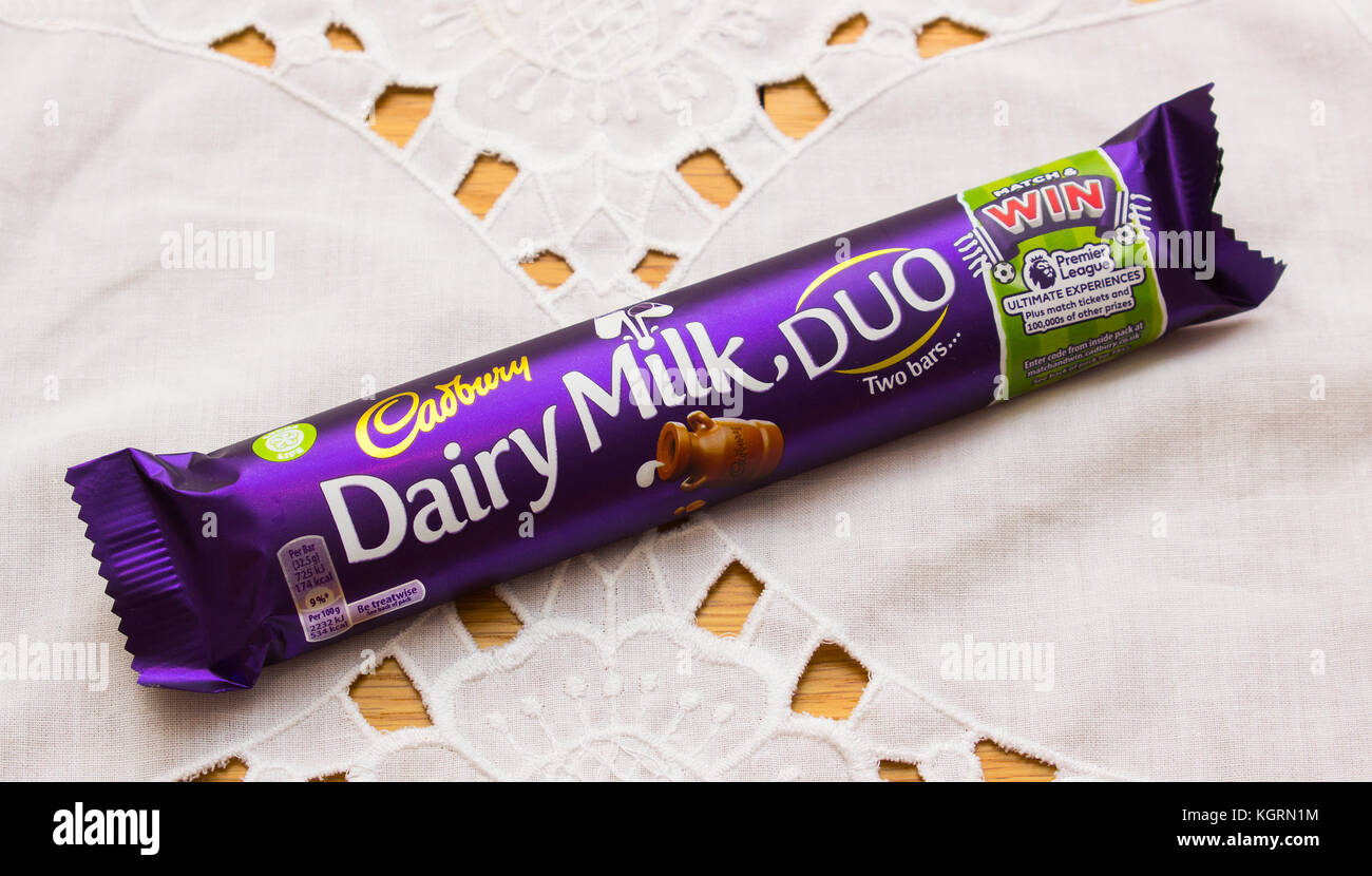 Una deliziosa tavoletta di cioccolato al latte Cadbury in una confezione colorata e luminosa pronta per il consumo Foto Stock