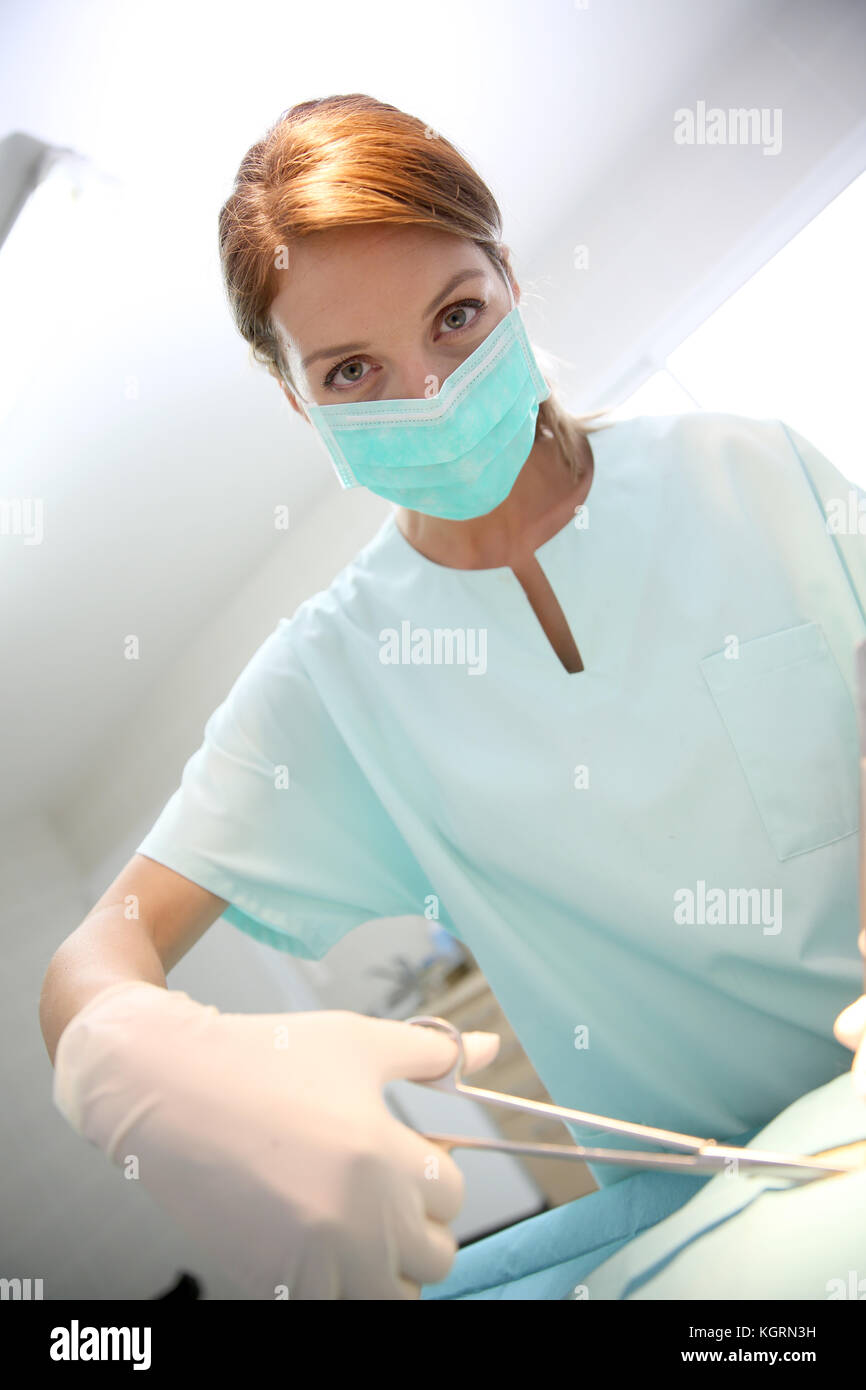 Chirurgo donna con maschera in sala operatoria Foto Stock