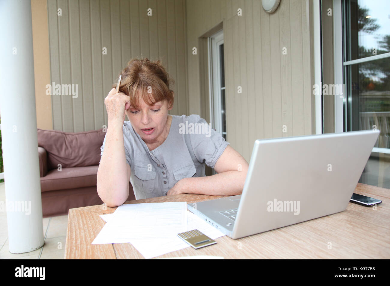 Senior donna avendo difficoltà con la dichiarazione fiscale Foto Stock