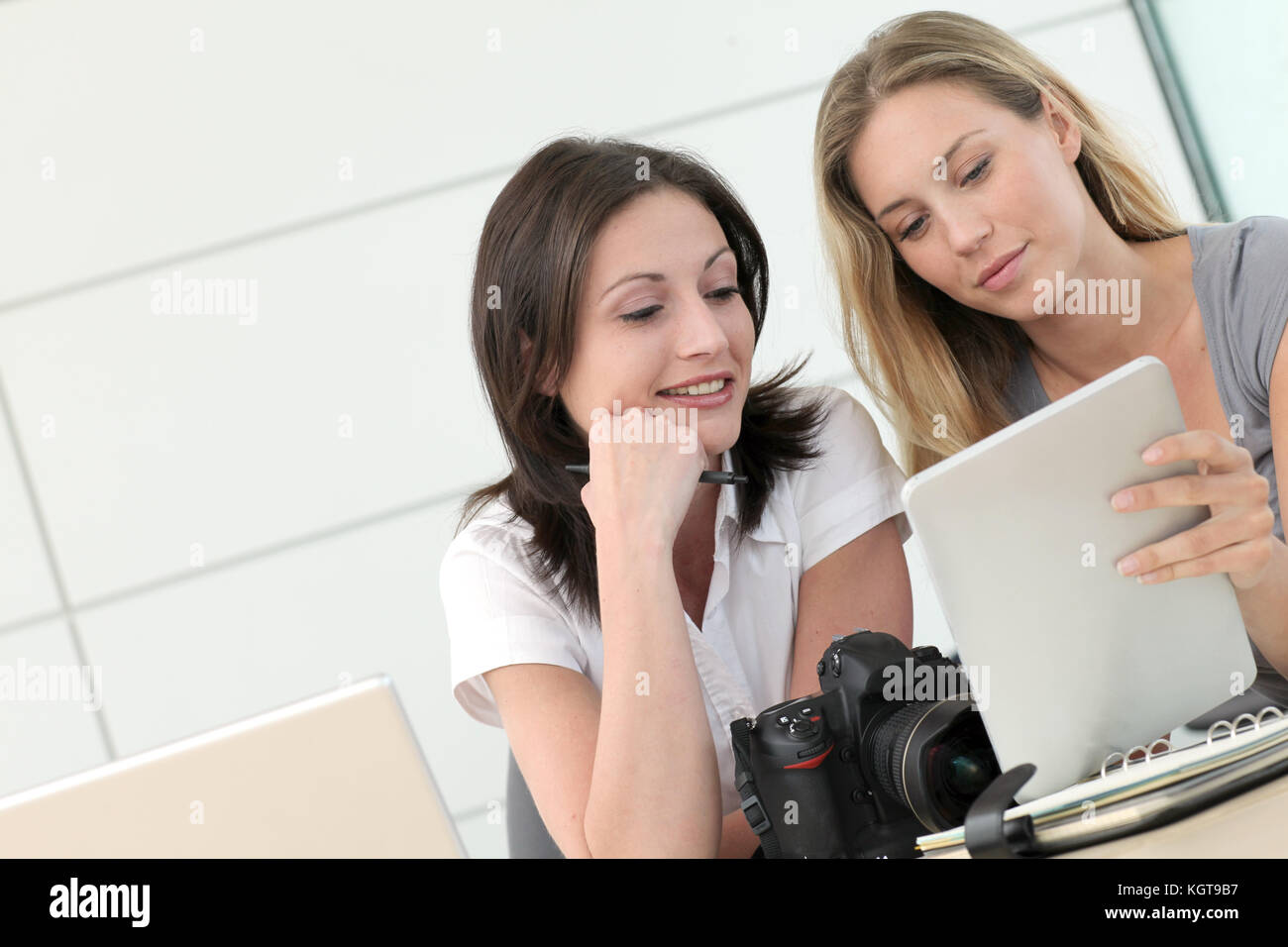 Le donne i fotografi che lavorano in ufficio con tablet Foto Stock