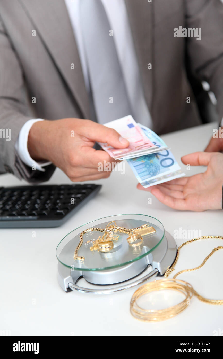 Oro contro denaro contante Foto Stock