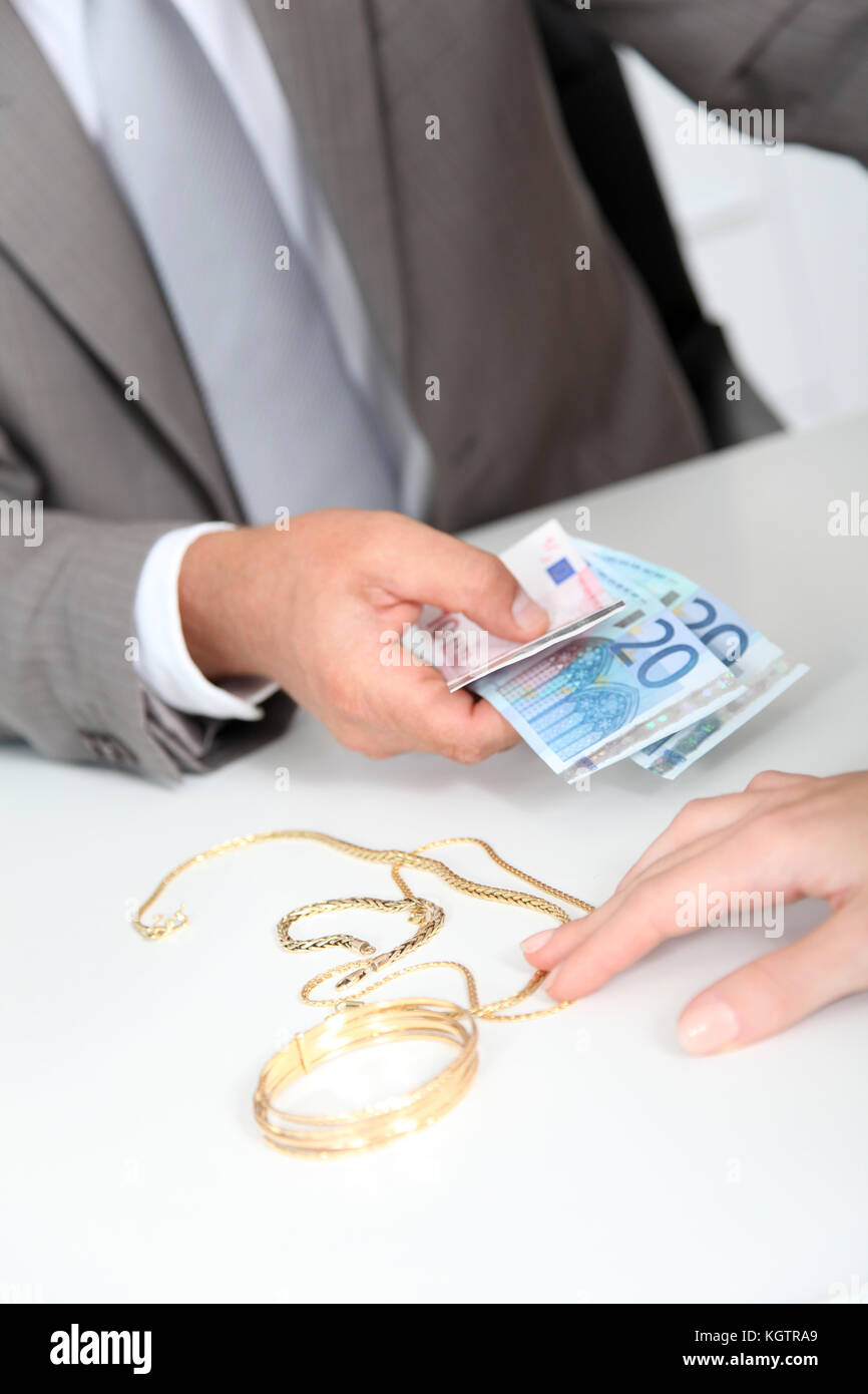 Oro contro denaro contante Foto Stock