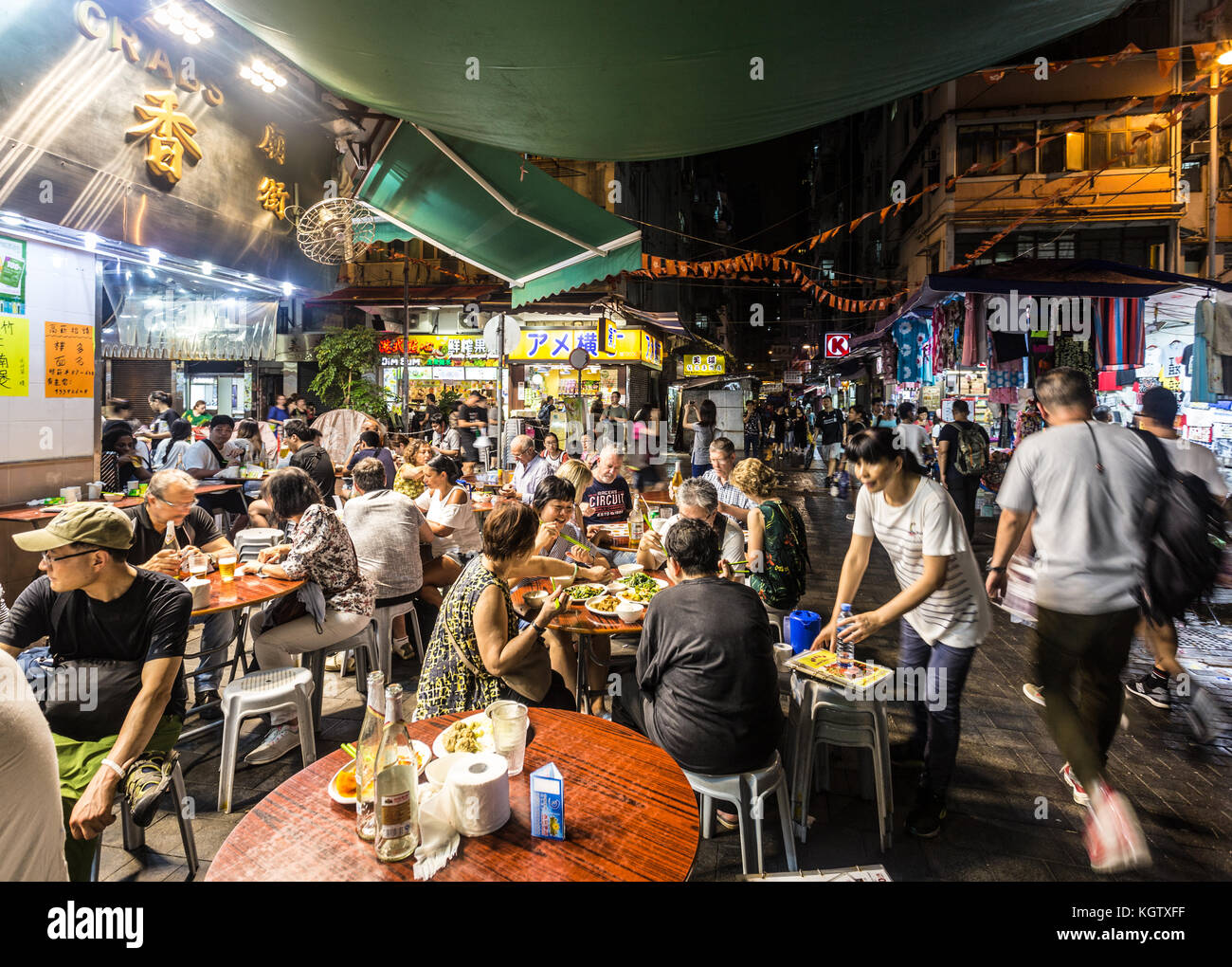Hong Kong, Cina - 16 giugno 2017: turisti e locali di cenare in un ristorante per le strade di Kowloon vicino al famoso tempio del mercato notturno di Hong kong. Foto Stock