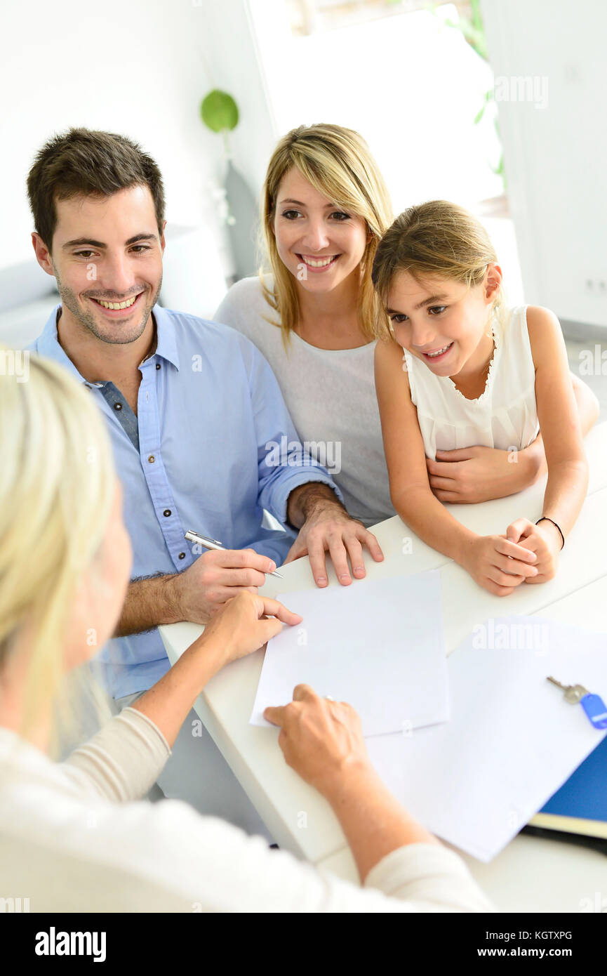 Famiglia firma contratto con home venditore Foto Stock