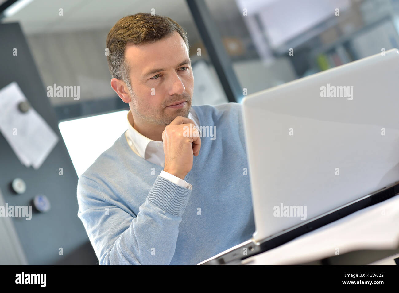 Gestione industriale in ufficio a lavorare sul computer portatile Foto Stock