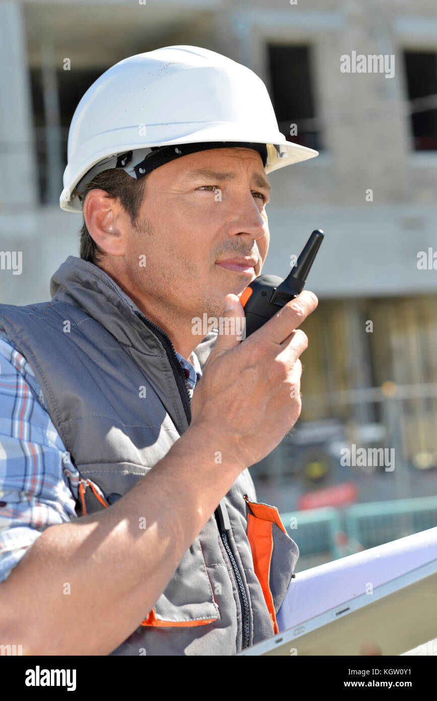 L'uomo sul sito di costruzione utilizzando un walkie-talkie Foto Stock