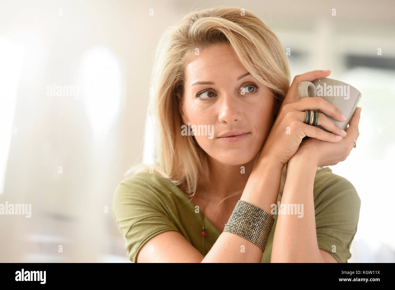 Attraente bionda donna di mezza età fustellatura tè caldo Foto Stock