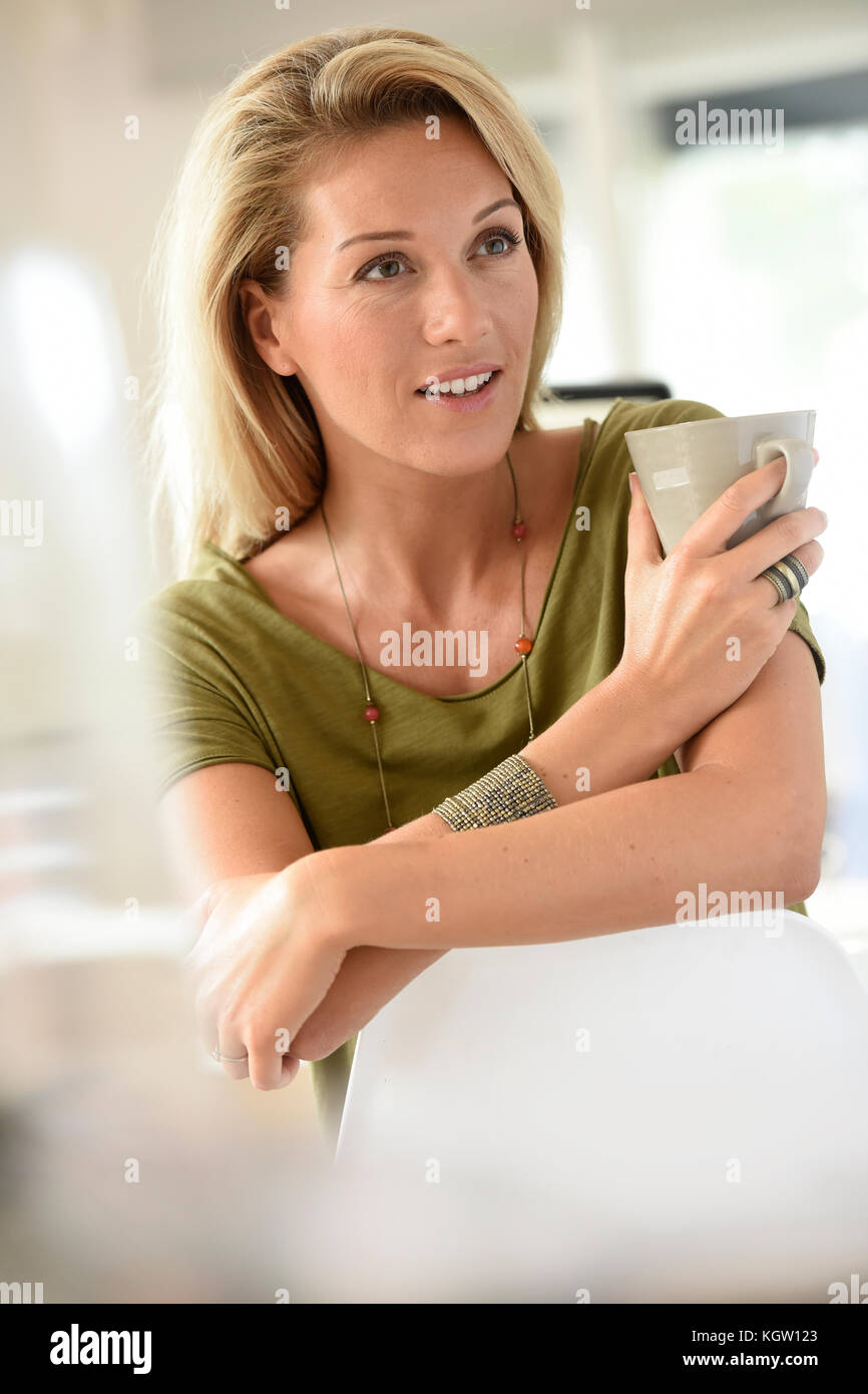 Attraente bionda donna di mezza età fustellatura tè caldo Foto Stock