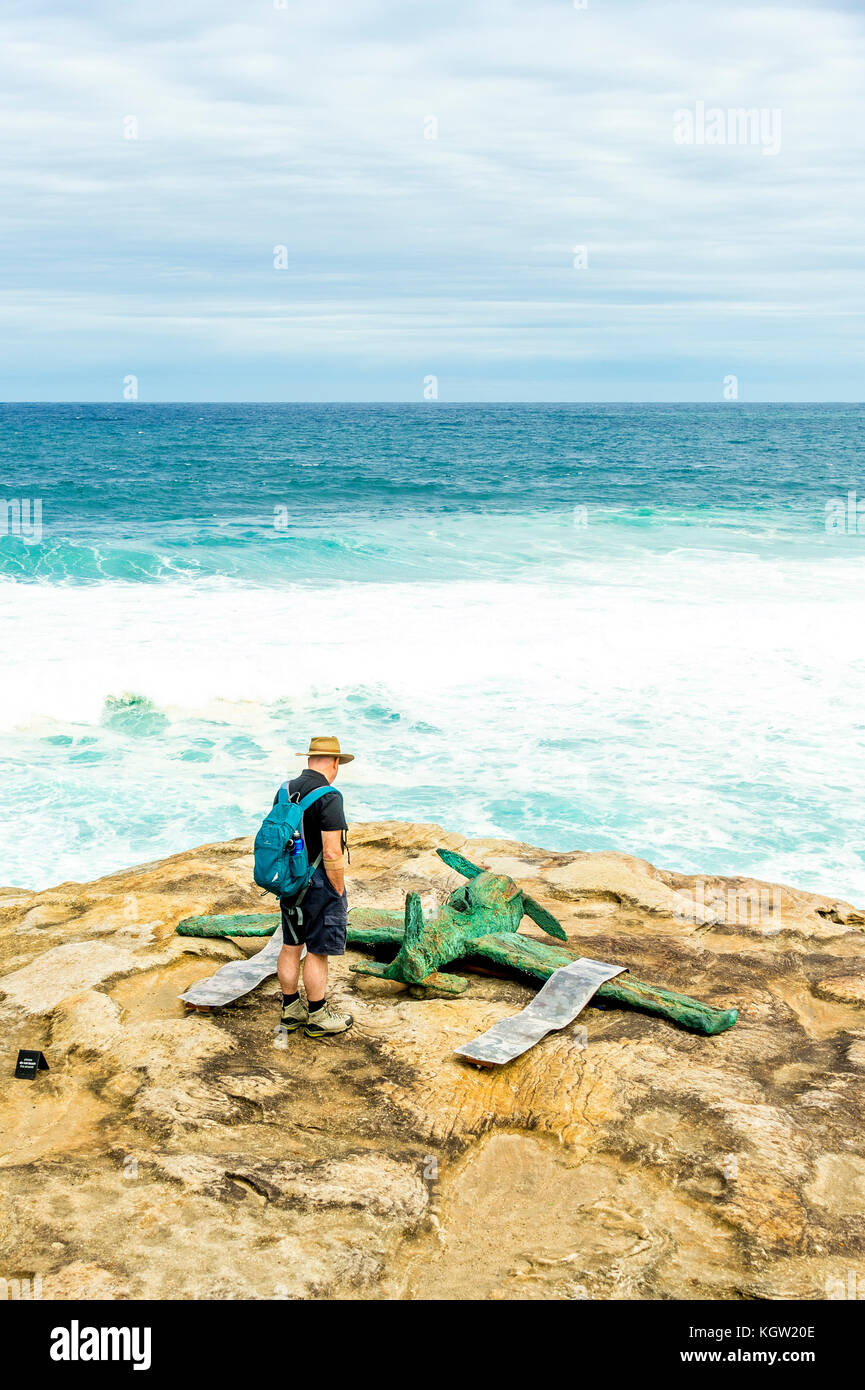 Un turista ammira Stephen Harrison opera intitolata "Olly e Charles' durante il 2017 le sculture del mare vicino a Bondi Beach a Sydney Foto Stock