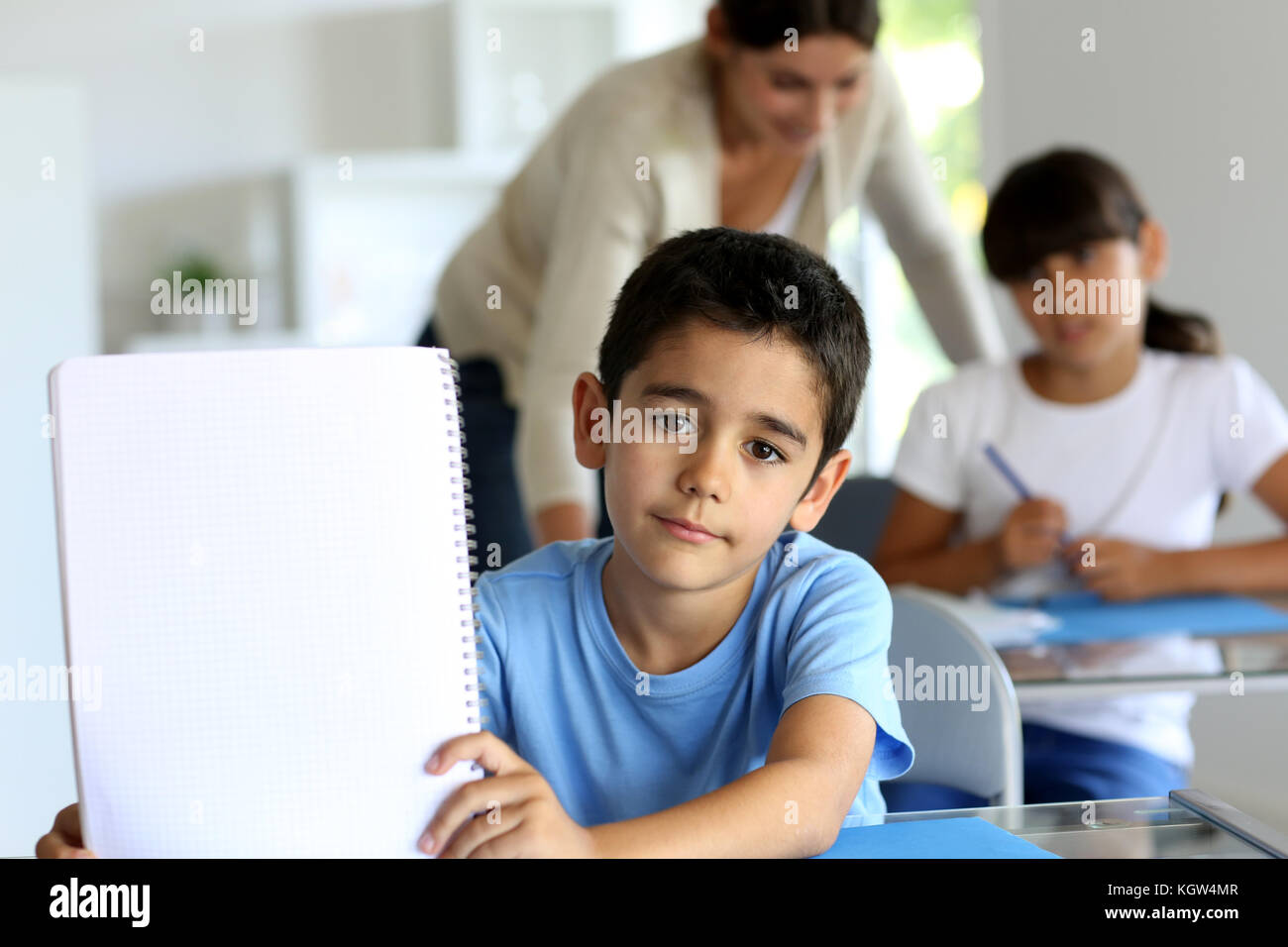 Ritratto di carino piccolo ragazzo che mostra notebook verso la telecamera Foto Stock