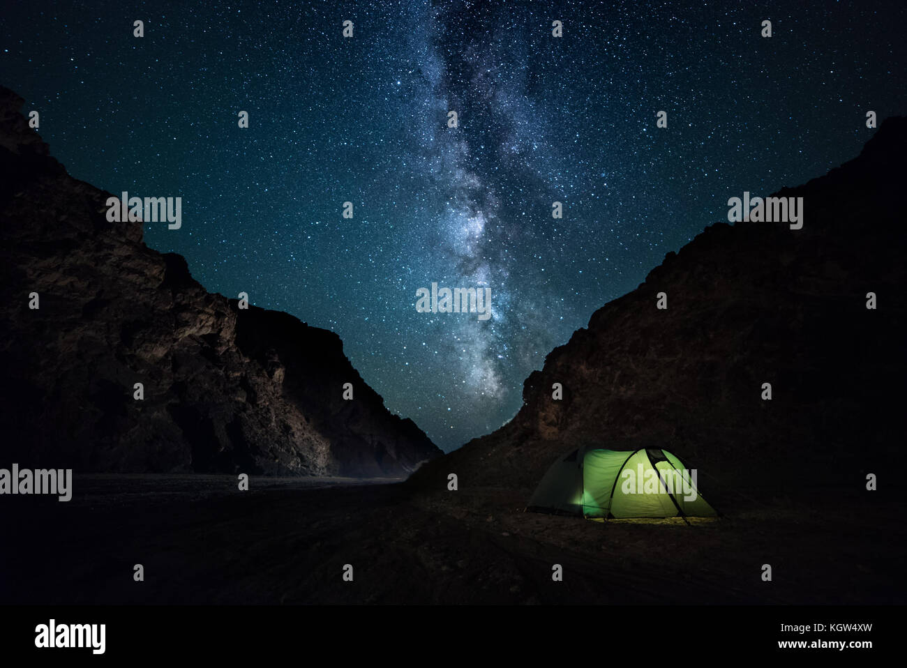 Notte anfratto roccioso, cielo stellato con brillante Via Lattea. Un piccolo campeggio Foto Stock
