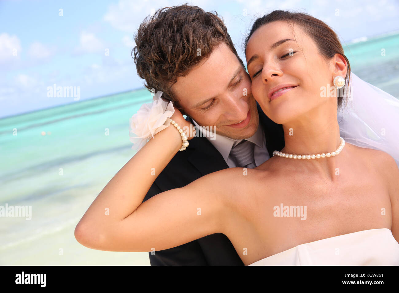 Appena una coppia sposata in piedi su una spiaggia paradisiaca Foto Stock