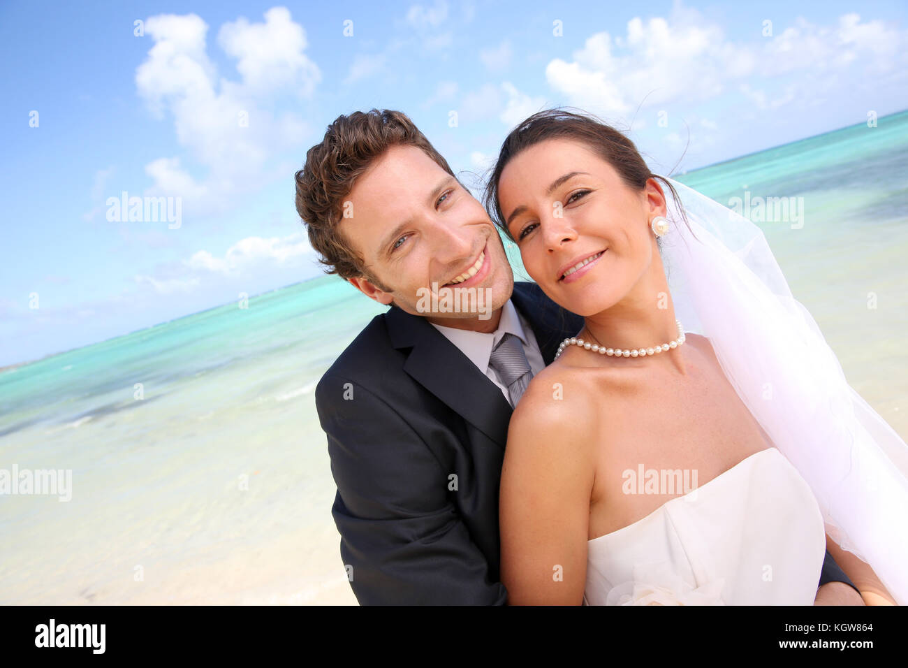 Appena una coppia sposata in piedi su una spiaggia paradisiaca Foto Stock