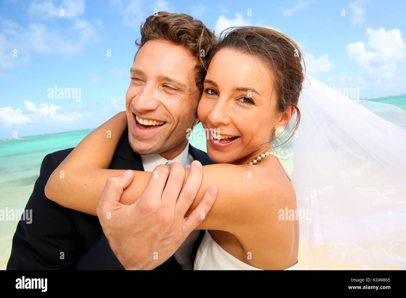 Appena una coppia sposata in piedi su una spiaggia paradisiaca Foto Stock